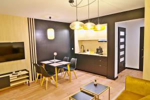 a living room with a table and a kitchen at Apartament Alina 25 in Biała Podlaska