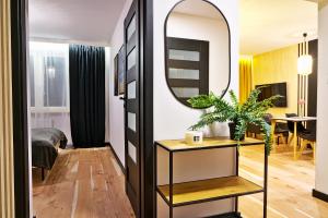 a bedroom with a mirror and a table with a plant at Apartament Alina 25 in Biała Podlaska