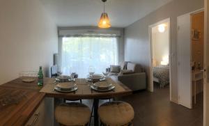 a kitchen and living room with a table and chairs at Le Carré des Vosges Vannes centre avec terrasse, parking privatif, Wifi in Vannes +6 photos
