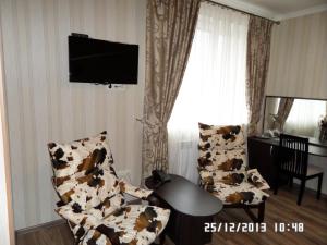 a living room with two chairs and a television at Royal Hotel in Kharkiv