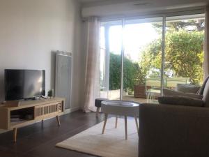 a living room with a flat screen tv and a couch at Le Carré des Vosges Vannes centre avec terrasse, parking privatif, Wifi in Vannes