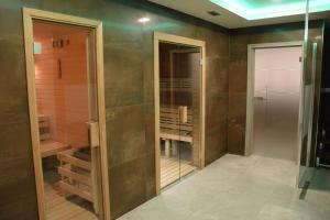 a bathroom with a walk in shower and a glass door at Anna SPA & Wellness Hotel Nejdek in Nejdek