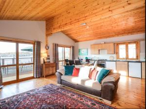 a living room with a couch and a kitchen at Osprey Lodge in Tattershall