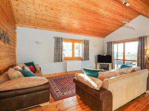 uma sala de estar com dois sofás e uma televisão em Osprey Lodge em Tattershall
