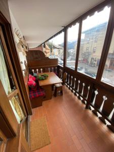 a balcony with a table and a piano in a building at Incantevole monolocale in centro a Cortina. in Cortina dʼAmpezzo