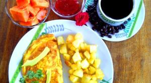 a table with a plate of breakfast food and a cup of coffee at Bahia B&B in Bahía de Caráquez