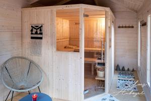 a wooden shed with a chair in a room at Chalet La Revoyotte in Le Ménil