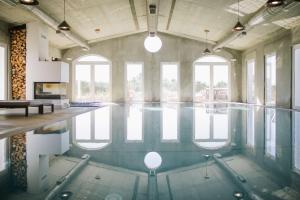 a swimming pool in a large room with windows at Craveiral Farmhouse by Belong Staying & Feeling in São Teotónio