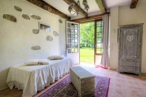 a bedroom with two beds and an open door at L'Oustal Chambres et Tables d'Hôtes in Sonnac