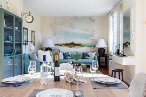 a dining room with a table with wine glasses at Hâvre de paix sous les pins, au coeur des Abatilles, avec sa superbe terrasse in Arcachon