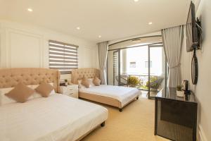 a bedroom with two beds and a tv and a couch at Phước Hưng 2 Hotel in Vĩnh Long