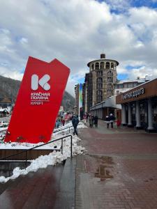 a red sign on a sidewalk in a city at Апартаменты Горки Город in Estosadok