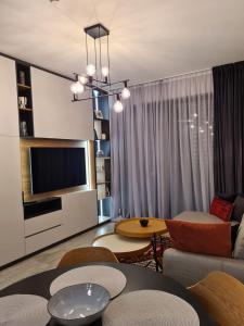 a living room with a couch and a tv at Stay and Spa Sarajevo Penthouse in Sarajevo