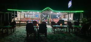 a group of people sitting at tables at night at Hare's BAR AND RESTAURANT in Canacona
