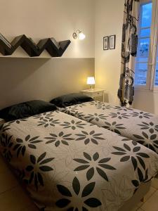 1 dormitorio con 2 camas y colcha con flores en Simons Apartments en Sliema