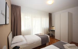 niewielka sypialnia z 2 łóżkami i biurkiem w obiekcie Apartman Nonno w Puli
