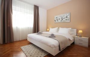 sypialnia z dużym białym łóżkiem i oknem w obiekcie Apartman Nonno w Puli