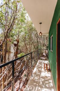 - un balcon d'une maison avec un mur vert et des arbres dans l'établissement Marília EcoHome Pipa, à Pipa