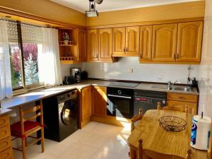 a kitchen with wooden cabinets and a wooden table at CASA RURAL COSTALAGO in Hontoria del Pinar +19 photos