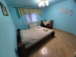 a bedroom with a bed in a blue room at Садиба Райський Куточок in Synevyr +34 photos