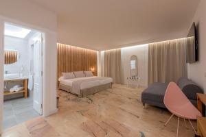 a bedroom with a bed and a couch in a room at Hotel Boutique Sibarys - Adults Recommended in Nerja
