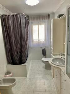 uma casa de banho com 2 lavatórios e uma cortina de chuveiro em CASA RURAL COSTALAGO em Hontoria del Pinar