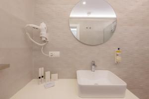 a white bathroom with a sink and a mirror at Hotel Boutique Sibarys - Adults Recommended in Nerja