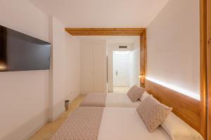 a bedroom with a bed and a flat screen tv at Hotel Boutique Sibarys - Adults Recommended in Nerja