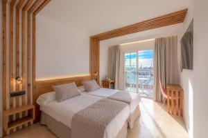 a hotel room with a bed and a balcony at Hotel Boutique Sibarys - Adults Recommended in Nerja