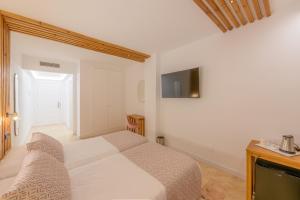a bedroom with a bed and a tv on the wall at Hotel Boutique Sibarys - Adults Recommended in Nerja