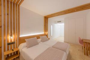 a bedroom with a bed and a table and a desk at Hotel Boutique Sibarys - Adults Recommended in Nerja