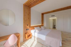 a bedroom with a white bed and a pink chair at Hotel Boutique Sibarys - Adults Recommended in Nerja