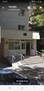 een gebouw met trappen en een gebouw met een auto voor de deur bij Avrig-Ferdinand Studio in Boekarest