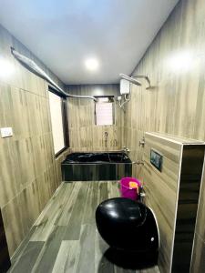 阿利巴格的住宿－Bliss Rooms，坐在浴室中间的黑色奥斯曼