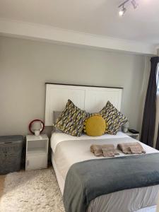 a bedroom with a bed with two pillows on it at Tana’s Crib(Modern Secure 1 bed Apartment)Beaumont in Cape Town
