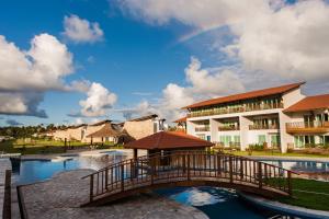 a bridge over a river in front of a building at Club Meridional Praia dos Carneiros - Perto da Igrejinha in Praia dos Carneiros