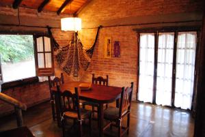 a dining room with a wooden table and chairs at CABAÑAS LA ARBOLEDA DE TOMASA in Villa Rumipal
