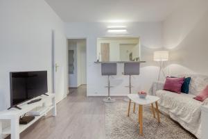 a living room with a couch and a tv at Le cocon des couples tout proche Versailles - en face de l'Hôpital Mignot in Le Chesnay