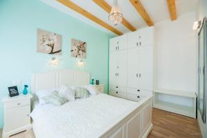 a bedroom with a white bed and white cabinets at Aldo Apartments Center in Zadar