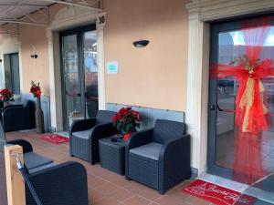- une terrasse couverte avec des chaises et des arcs dans un bâtiment dans l'établissement Hotel Aurora, à Varazze