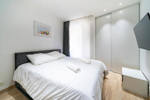a bedroom with a white bed and a window at Frontière Monaco, Terrasse, Vue Mer, Parking - AB in Beausoleil