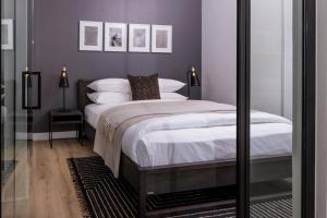 a bedroom with a large bed with purple walls at 5 Star Elegant Apartments, Ellipse Waterfall City, Midrand, Johannesburg in Midrand