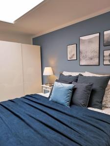 a blue bedroom with a large bed with pillows at Appartement Sterne in Senftenberg