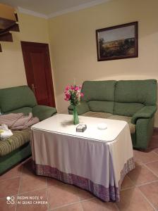 a living room with a table with a vase of flowers on it at Casa Carrasco in Algar