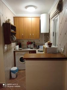 a kitchen with wooden cabinets and a washer and dryer at Casa Carrasco in Algar