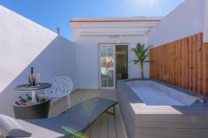 a tub in a room with a table and a chair at Hotel Boutique Sibarys - Adults Recommended in Nerja