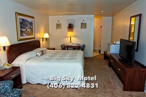 a hotel room with a bed and a flat screen tv at Big Sky Motel in Superior