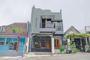 un edificio con balcón en el lateral de una calle en OYO 90737 Losmen Aini Syariah en Batu