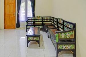 three benches lined up in a room with a door at OYO 90737 Losmen Aini Syariah in Batu