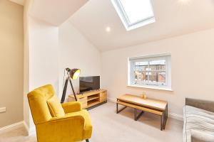 a living room with a yellow chair and a table at Barnes boutique apartment in Sunderland